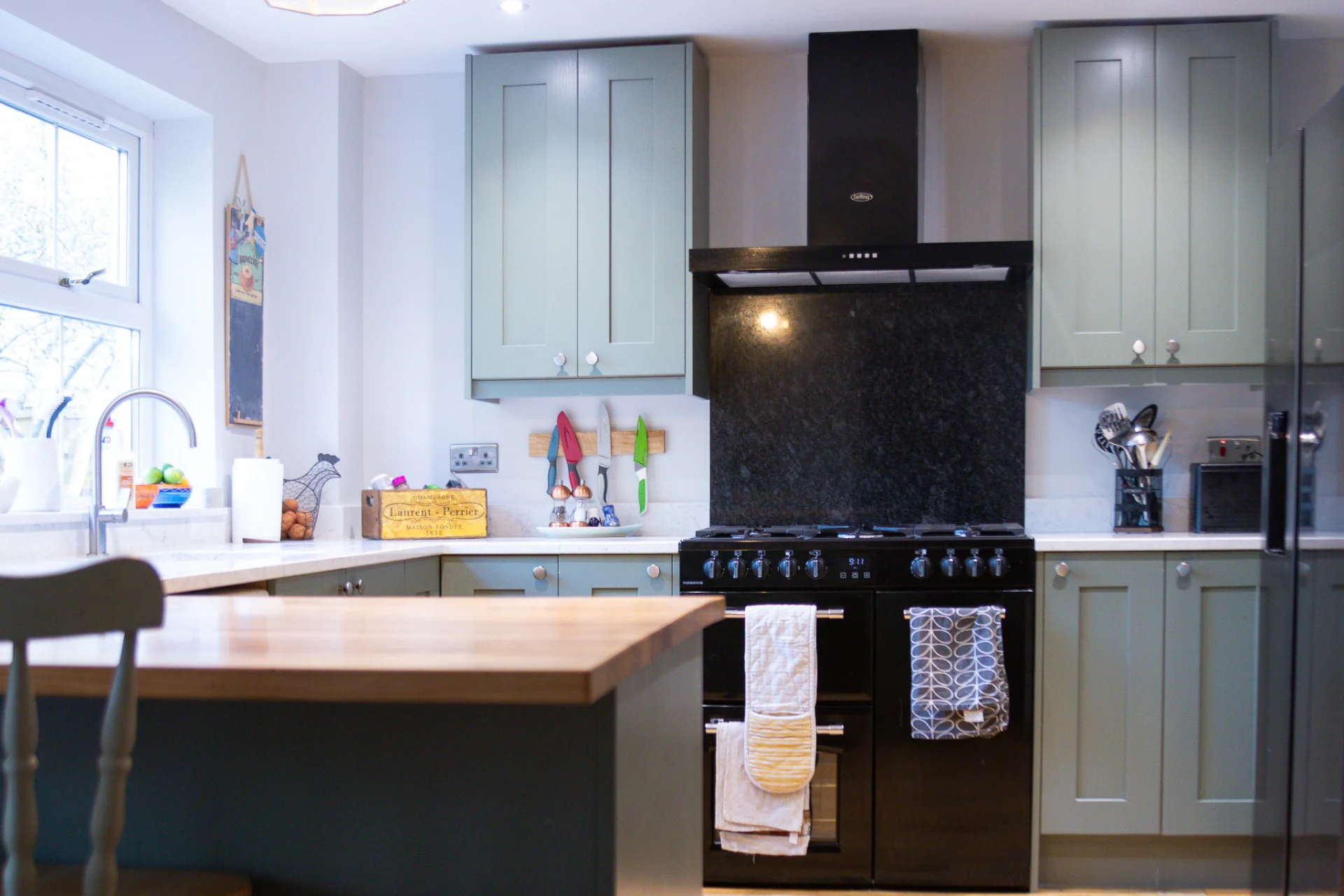 Regiment Green shaker kitchen with range cooker and oak peninsula