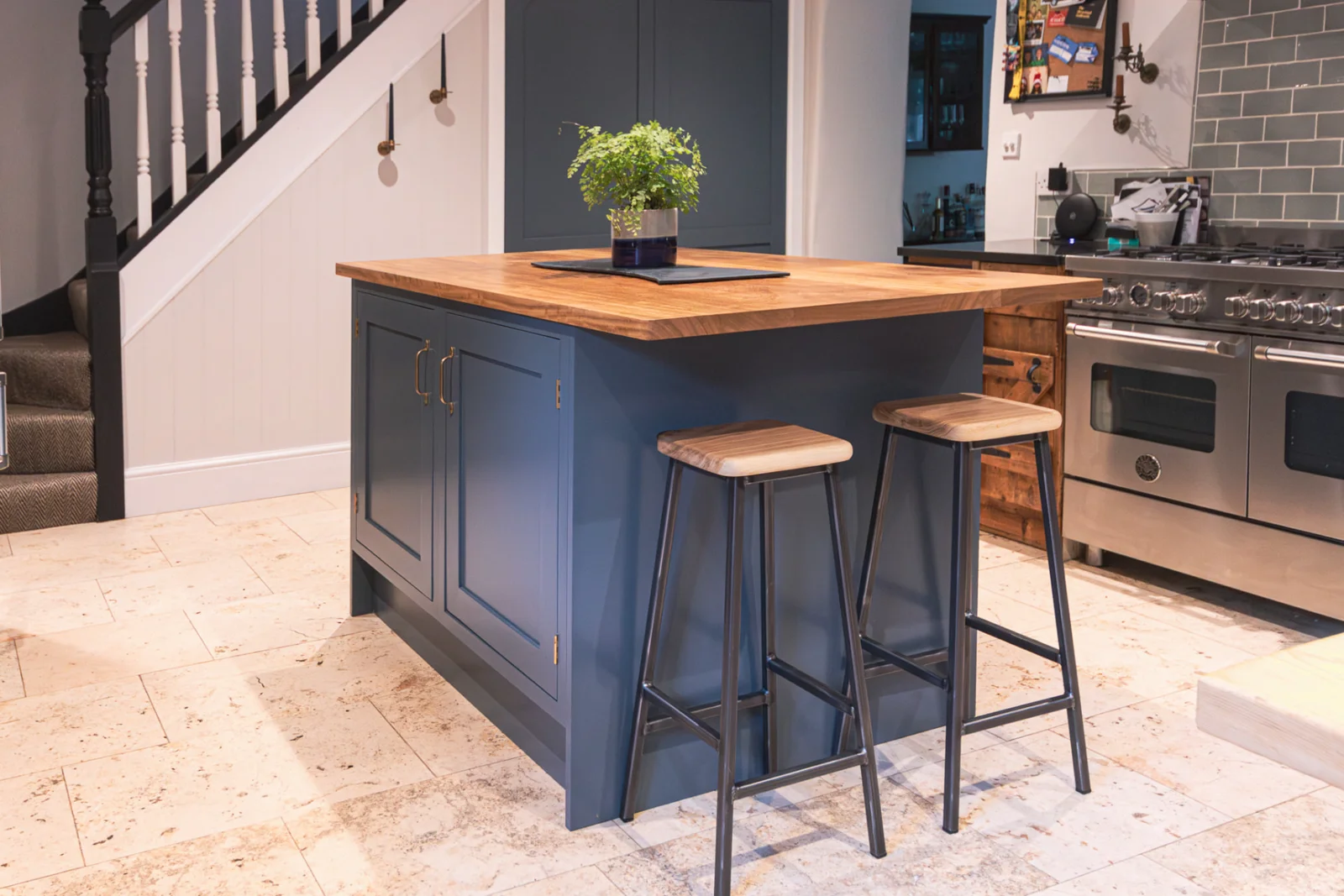 Navy blue painted kitchen island with solid timber top and bar stools in a Wiltshire kitchen
