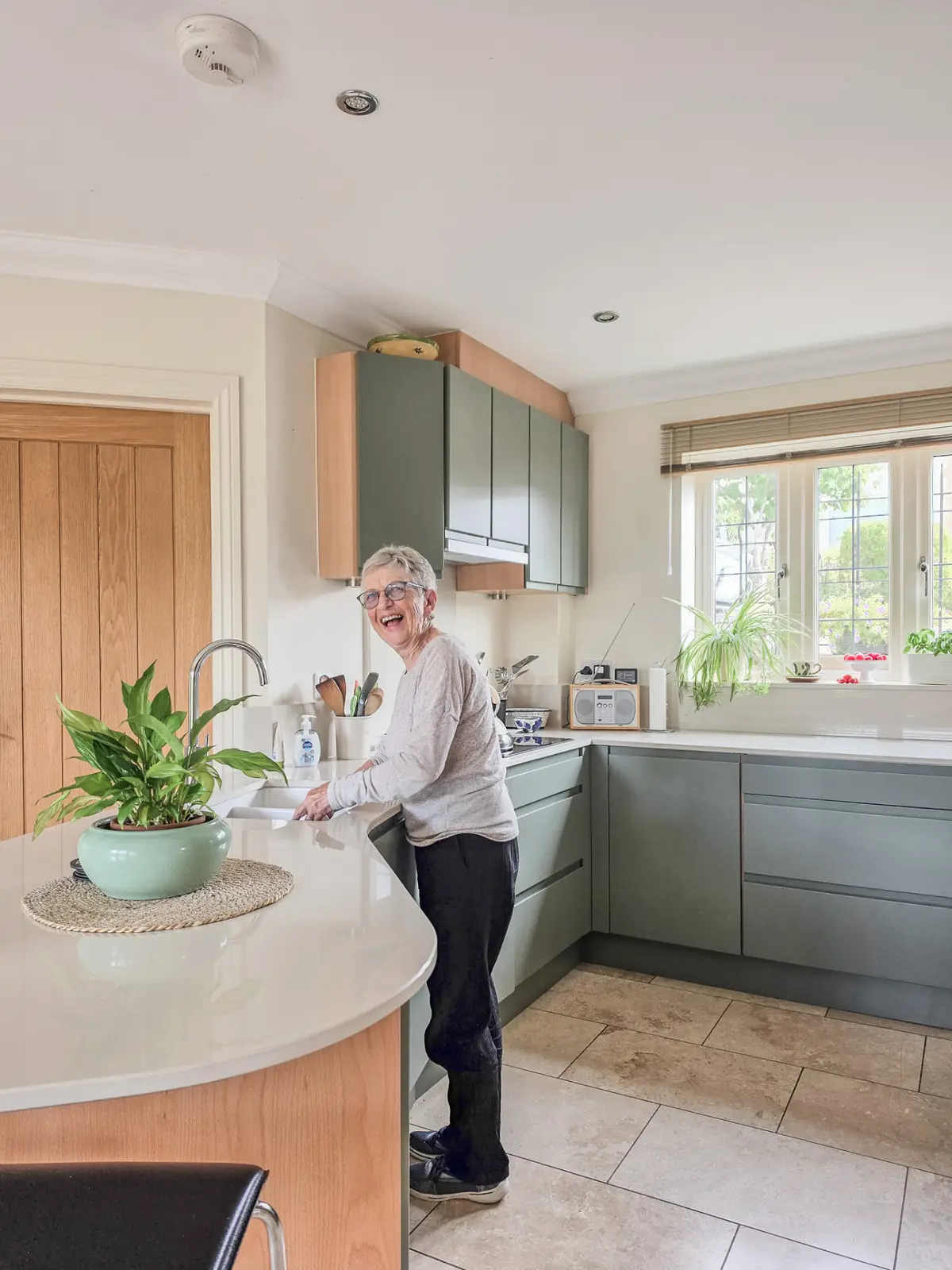 Delighted client at her new undermount sink and tap in the refreshed kitchen