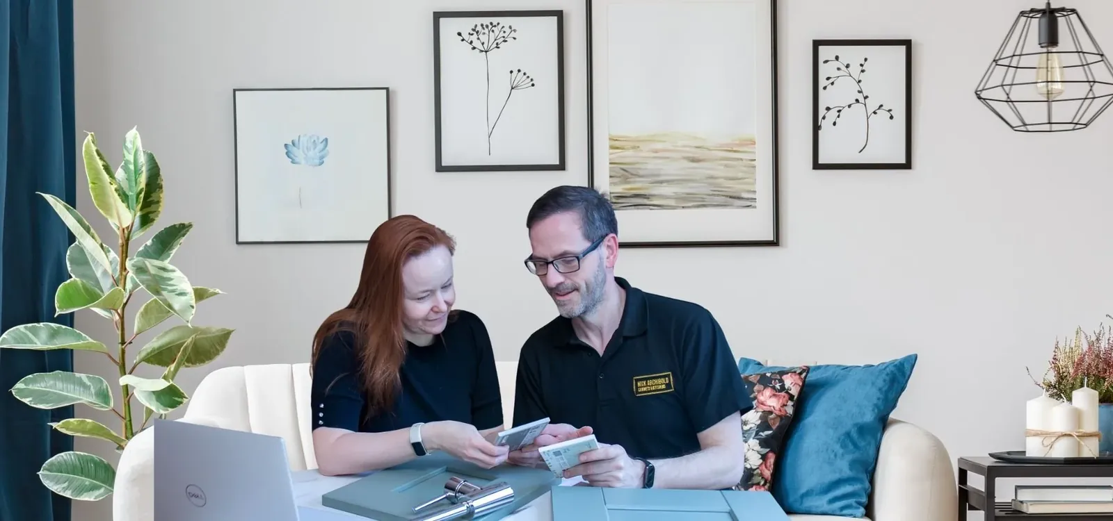Nick showing timber and paint samples to a couple at their kitchen table
