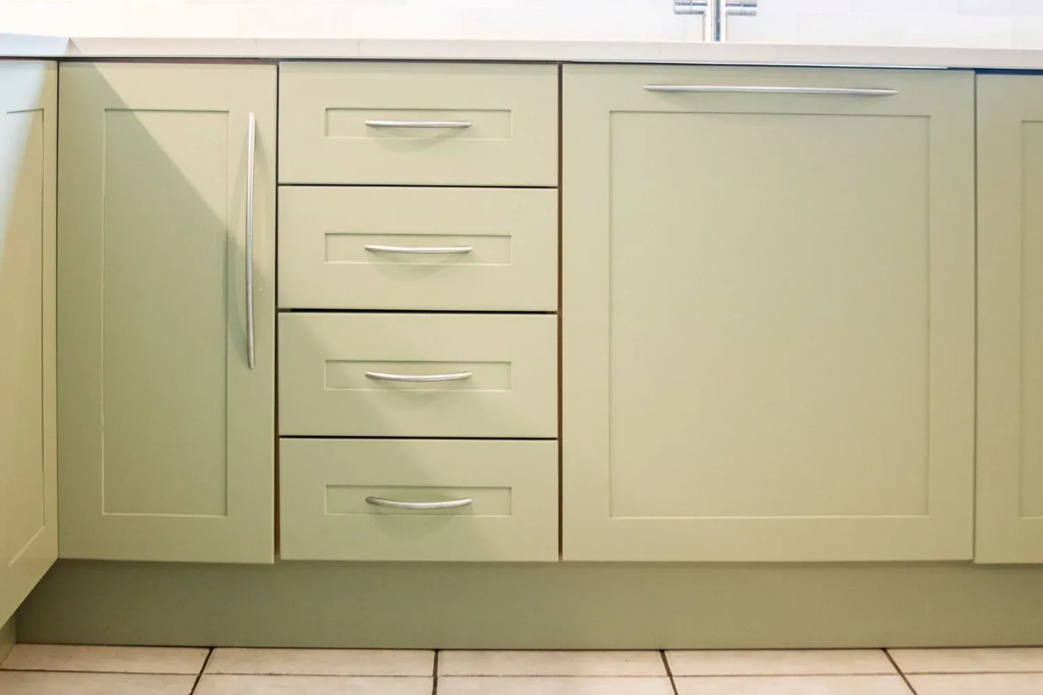 Freshly sprayed drawer fronts in a soft green